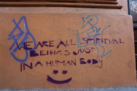 Vichni jsme duchovní bytosti v lidském tle, upozoruje nápis zachycený v centru Prahy.