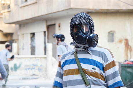 Syrští povstalci (na snímku jeden z nich v plynové masce na východním předměstí Damašku) se snaží připsat chemický útok režimu Bašára Asada. Podle Jana Schneidera to ale nedává smysl.