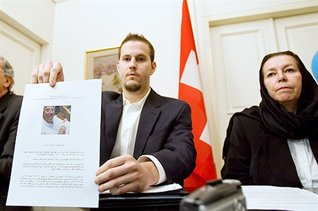 Manželka Roberta Levinsona Christine se synem Danielem, který novinářům ukazuje portrét svého otce (švýcarská ambasáda v Teheránu, 22. prosince 2007).