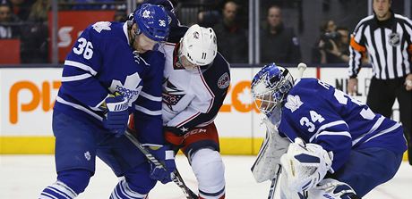 Obránce Toronto Maple Leafs bojuje o puk s hráem Columbusu