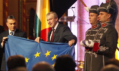 Belgický premiér Yves Leterme (vpravo) předává 6. ledna 2011 v Budapešti svému maďarskému protějšku Viktoru Orbánovi vlajku Evropské unie. Maďarsko se ujalo předsednictví EU, přestože Orbán byl kvůli maďarskému mediálnímu zákonu označován za posledního č
