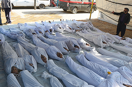 Syrští aktivisté prohlížejí těla lidí, kteří 21. srpna zahynuli při útoku nervovým plynem v příměstské oblasti Damašku Ghúta.