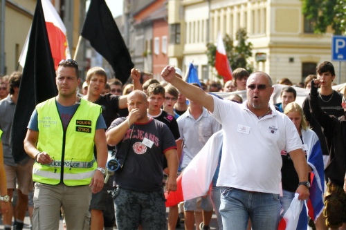 Demonstrace „proti systému vyplácení sociálních dávek, proti duchcovské kriminalitě“ v sobotu 24. srpna v Duchcově. Jindřich Svoboda je uprostřed v tmavém tričku s megafonem přes rameno.