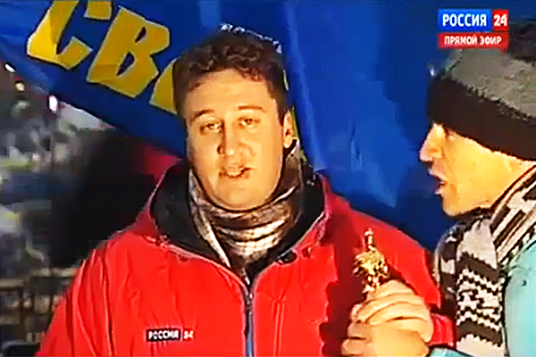 Jeden z demonstrantů na kyjevském Majdanu vstoupil do záběru v živém vstupu ruského státního kanálu Rossija 24 a reportérovi předal maketu sošky hollywoodského Oscara „za herecký výkon“.