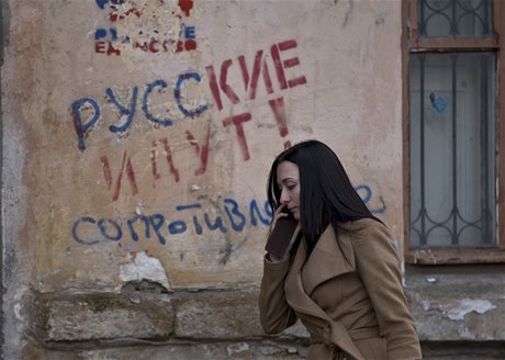 Žena míjí nápis na zdi simferopolského domu říkající "Rusové jdou! - Odpor". Výsledky nedělního referenda děsí především etnické Ukrajince a krymské Tatary žijící na tomto poloostrově.  