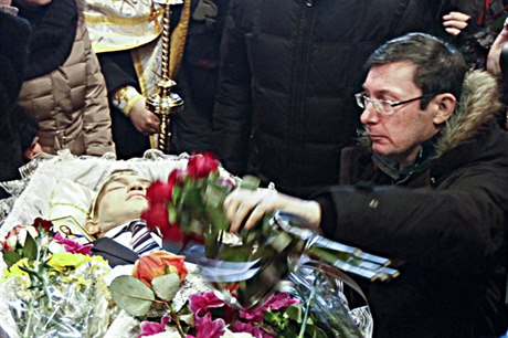 Jurij Lucenko klade kytici na rakev zabitého demonstranta.