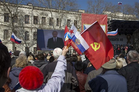 Nad davem sledujícím v Sevastopolu iv vysílaný Putinv projev vlály ruské vlajky a rudé prapory se srpem a kladivem.
