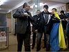 Mu mávající ukrajinskou vlajkou je blokován ostrahou krymského premiéra Sergeje Aksjonova. 