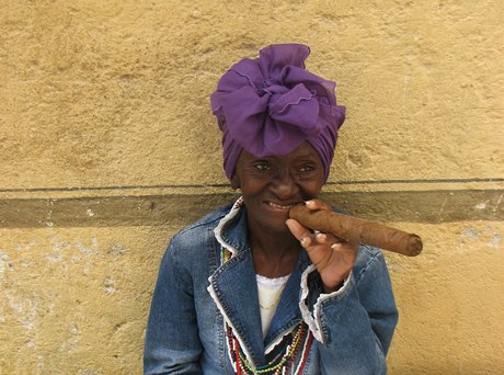 Z cestování po Kubě. Žena s obřím kubánským doutníkem.