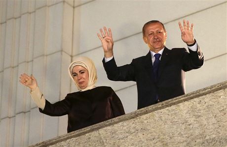 Recep Tayyip Erdogan s manelkou Emine zdraví své píznivce z balkónu sídla strany AKP. 