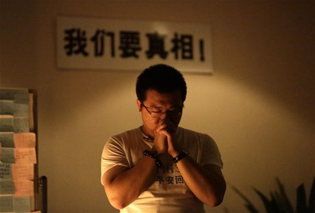 Píbuzní se modlí za osud posádky letu MH370.
