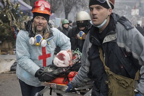 Záchranái pomáhají zrannému demonstrantovi (Majdan, 20. února 2014).