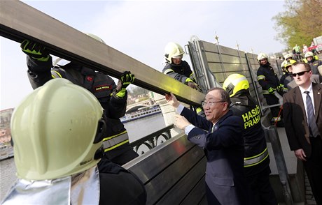 Pan Ki-mun pomáhá s pedvádcí stavou praských protipovodových zábran.
