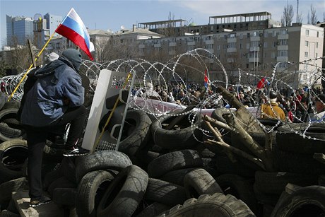Maskovaný separatista na barikádách ped sídlem oblastní správy v Doncku.