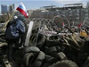 Maskovaný separatista na barikádách ped sídlem oblastní správy v Doncku.