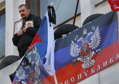 Proruský aktivista a vlajka samozvané Doncké lidové republiky.