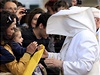 Pape Frantiek se zdraví s vícími, shromádnými ped ímským kostelem Panny Marie od Boské Prozetelnosti. Vítr si pohrává s jeho rouchem.