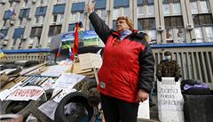 Proruská demonstrantka gestikuluje u barikád blokujících vchod do obsazené budovy ukrajinské rozvdky SBU v Luhansku.