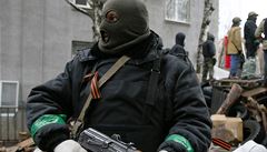 Ozbrojený mu stojí u barikády ped budovou policejního sídla ve mst Slavjansk.