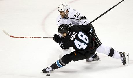 Obránce Los Angeles Willie Mitchell brání ve stelb útoníkovi San Jose Tomái Hertlovi