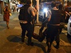 Policisté odnáejí demonstranta zranného bhem pouliních protest v Riu.