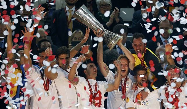 Fotbalisté Sevilly s trofejí pro vítze Evropské ligy.