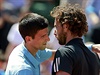 Novak Djokovi se objímá s Ernestsem Gulbisem po semifinále Roland Garros.
