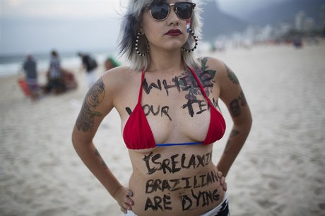 Aktivistka Sára Winter na plái v Rio de Janeiru s nápisem: "Zatímco tvj tým...