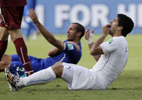 Luis Suárez (v bílém) se drí za zuby poté, co je obtiskl do ramena italského...