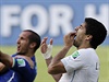 Luis Suárez (v bílém) se drí za zuby poté, co je obtiskl do ramena italského...