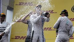Vít�z Velké ceny Rakouska Nico Rosberg (uprost�ed) dostává sprchu �ampa�ského...