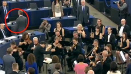 Europoslanec strany UKIP Nigel Farage se otoil k orchestru hrajícímu hymnu...