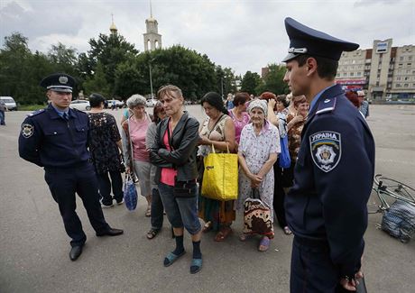 Obyvatel Slavjansku ekaj v doprovodu policist na humanitrn pomoc.
