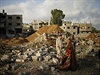 Palestinci stojí v troskách domu po izraelském náletu na pásmo Gazy.