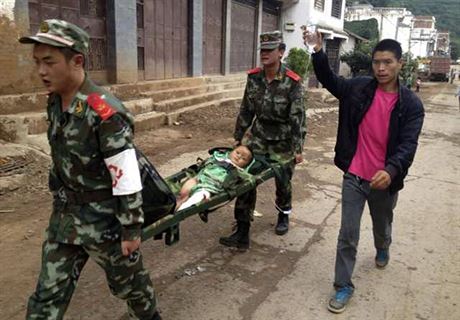 Zdravotníci odnáejí zranné po zemtesení v ínském mst Lung-tchou-an.