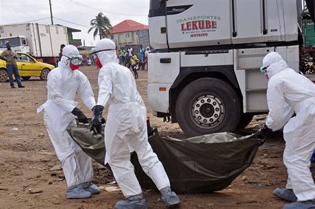Zdravotníci v ochranných oblecích penáejí tlo lovka zemelého na ebolu...