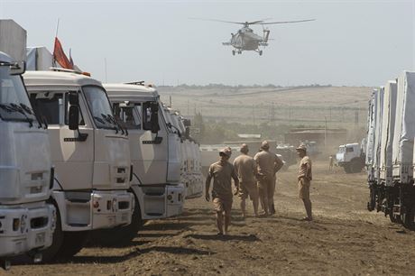Na zaparkovaný konvoj dohlíejí ruské vojenské vrtulníky.