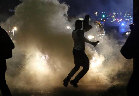 Boue v ulicích Fergusonu. Demonstranti uskakují ped slzným plynem, kterým...