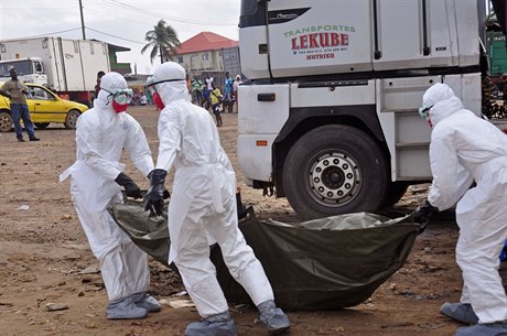 Zdravotníci v ochranných oblecích přenášejí tělo člověka zemřelého na ebolu...