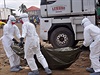 Zdravotnci v ochrannch oblecch penej tlo lovka zemelho na ebolu...