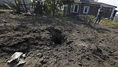 Obyvatel Don�cka stojí u kráteru vyhloubeného st�elou.