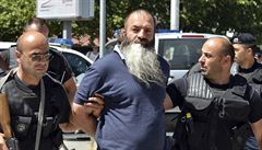 Kosovská policie odvádí zadreného imáma.