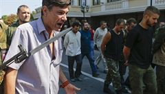 P�ehlídka zajatých voják� v Don�cku - mu� k�i�í po zajatcích.