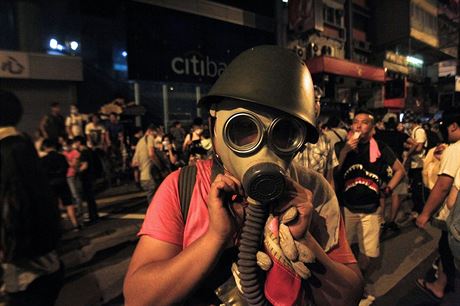Protestujc v hongkongsk obchodn tvrti Mongkok si nasazuje plynovou masku.