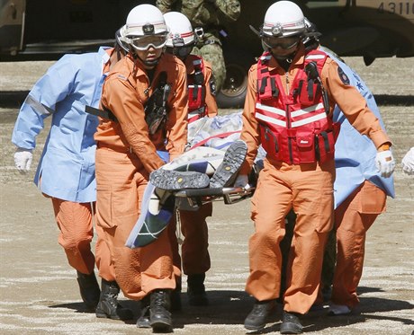 Záchranái nesou turistu zranného po výbuchu sopky na Mt. Ontake.