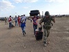 Voják pomáhá kurdským uprchlíkm se zavazadly.