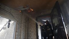 Hasi�i v Don�cku bojují s ohn�m v dom�, který se stal ter�em ost�elování.