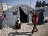 Kurdtí uprchlíci ze Sýrie sedí u stan na hranicích s Tureckem.