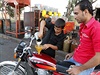 Chlapec ve mst Rakka dopluje benzín do motorky.