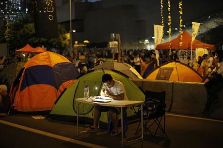 Studium nepoká. Mladý demonstrant v Hongkongu se ve volné chvíli uí.